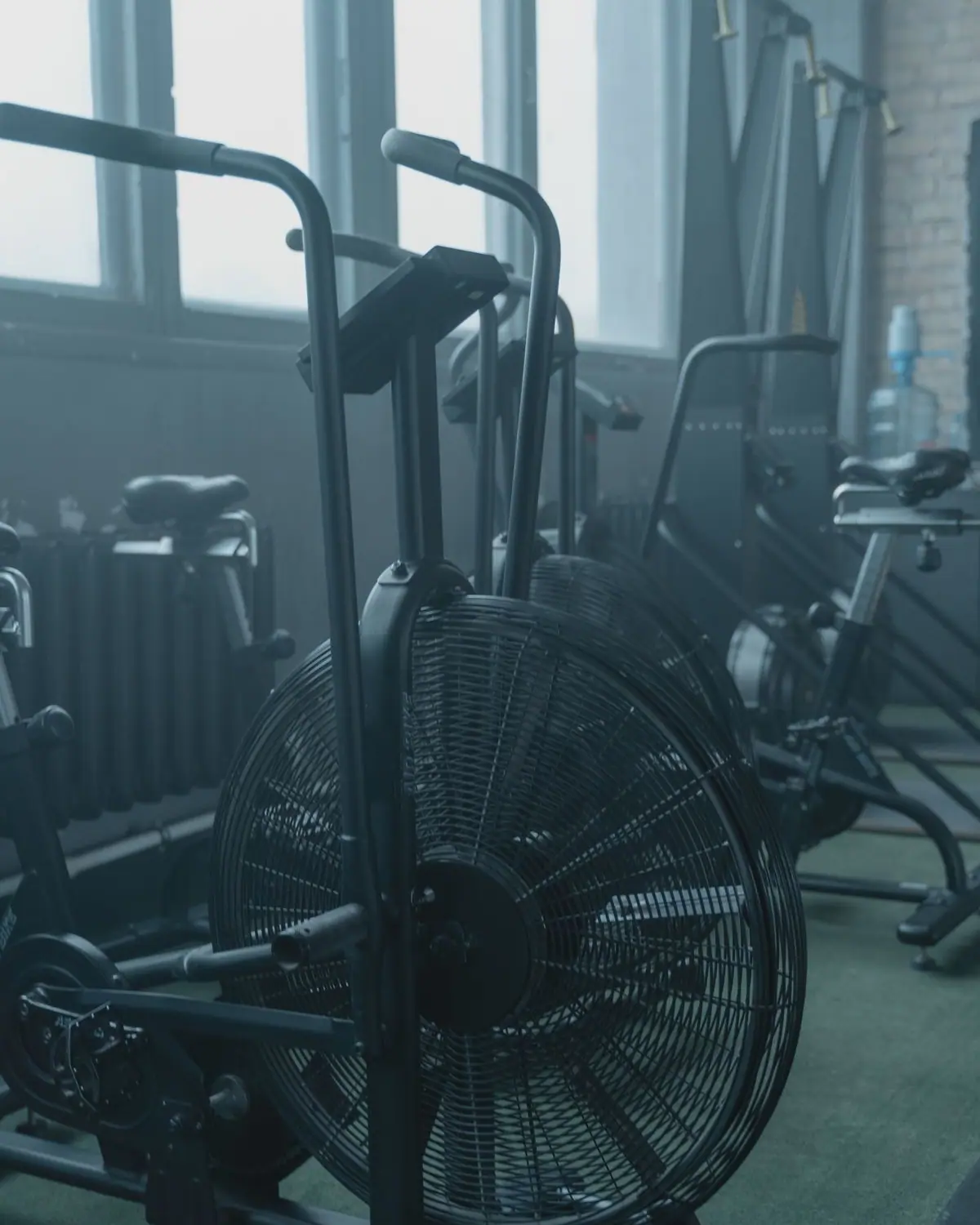 A row of exercise bikes in a bright gym