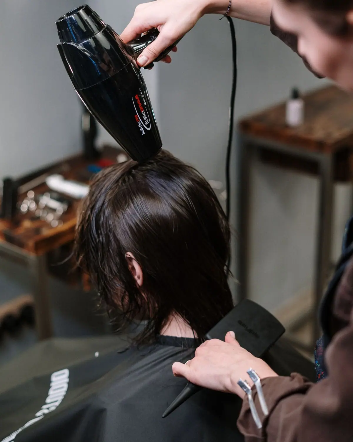 A stylist blow-drying a client's hair