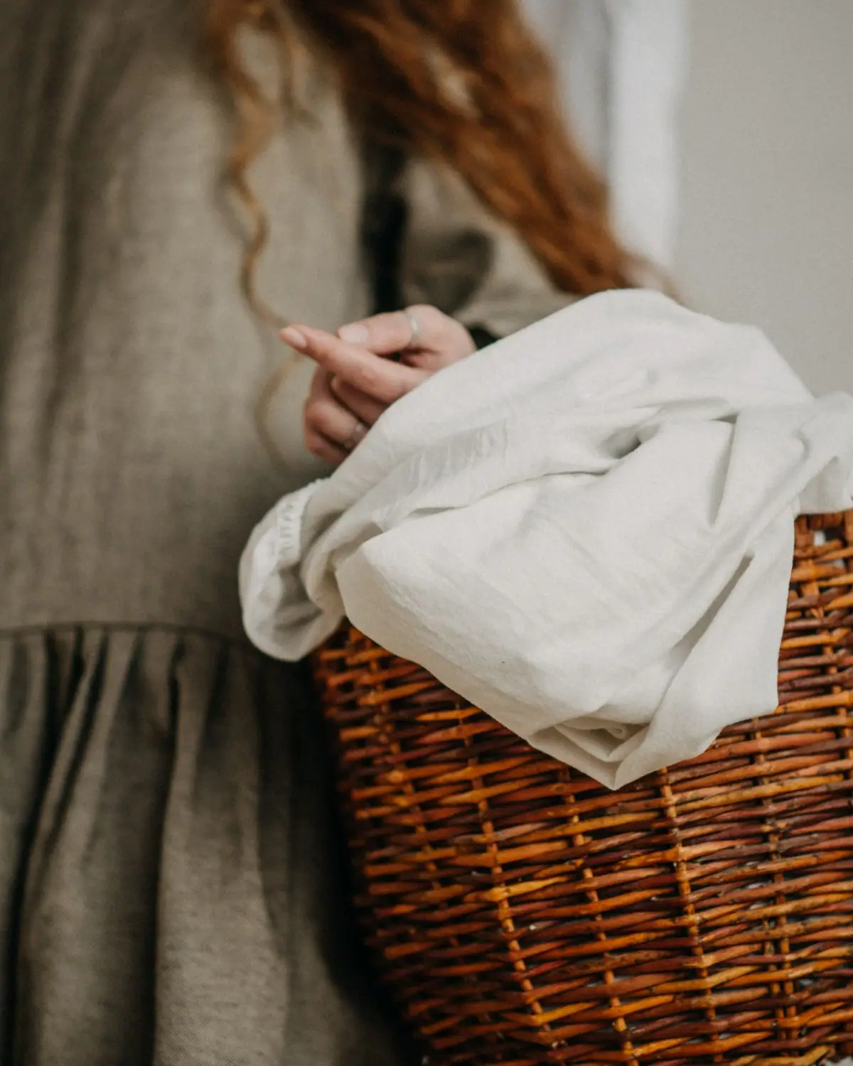 Folded linens in a woven laundry basket