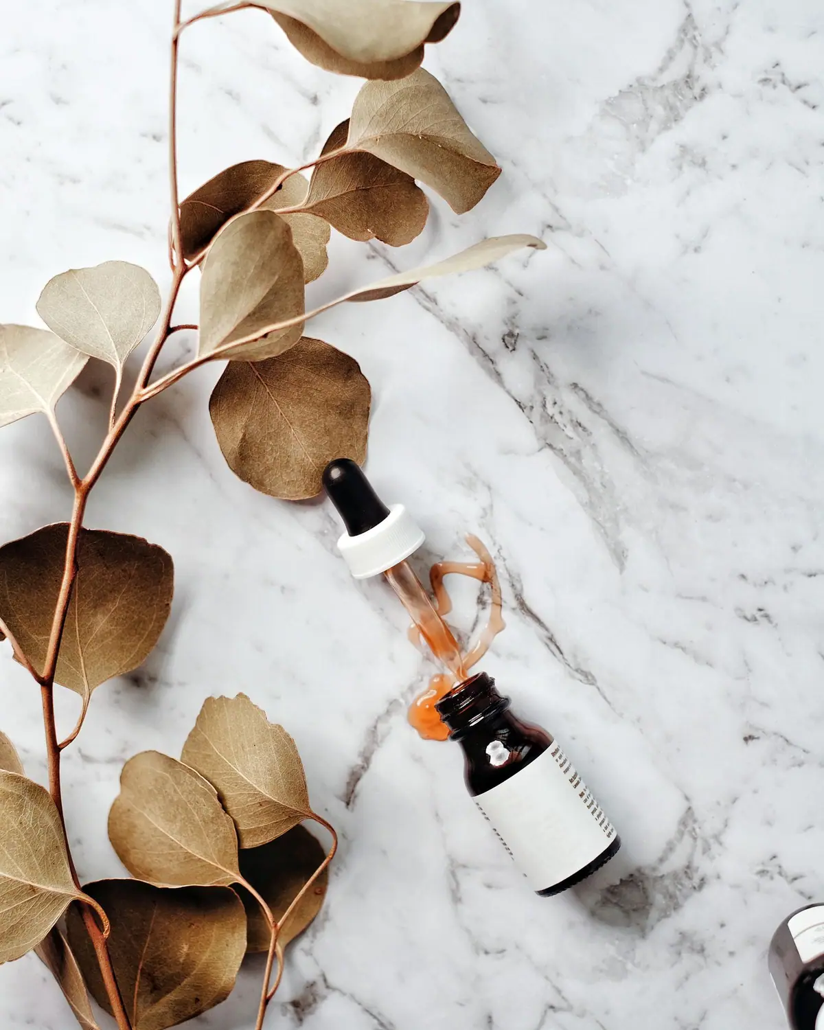 A luxury skincare serum glass bottle and pipette dropper
