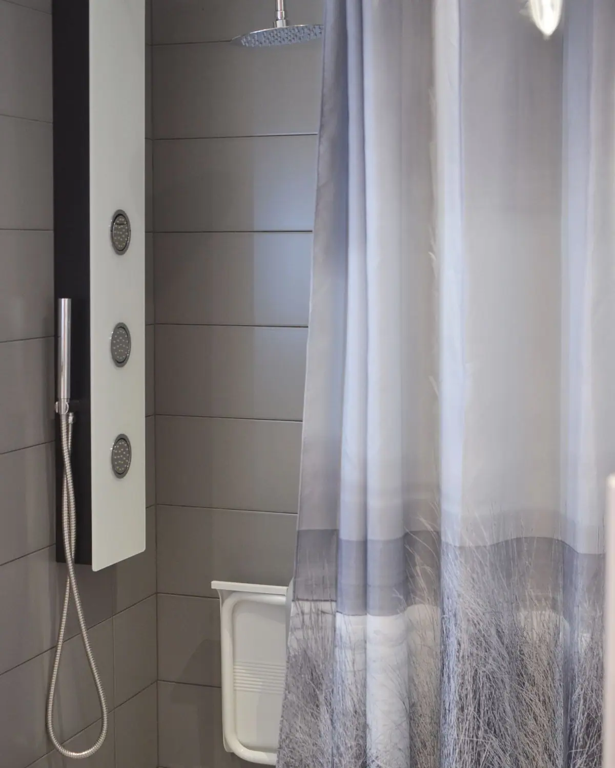A modern bathroom with a shower cabin and curtain