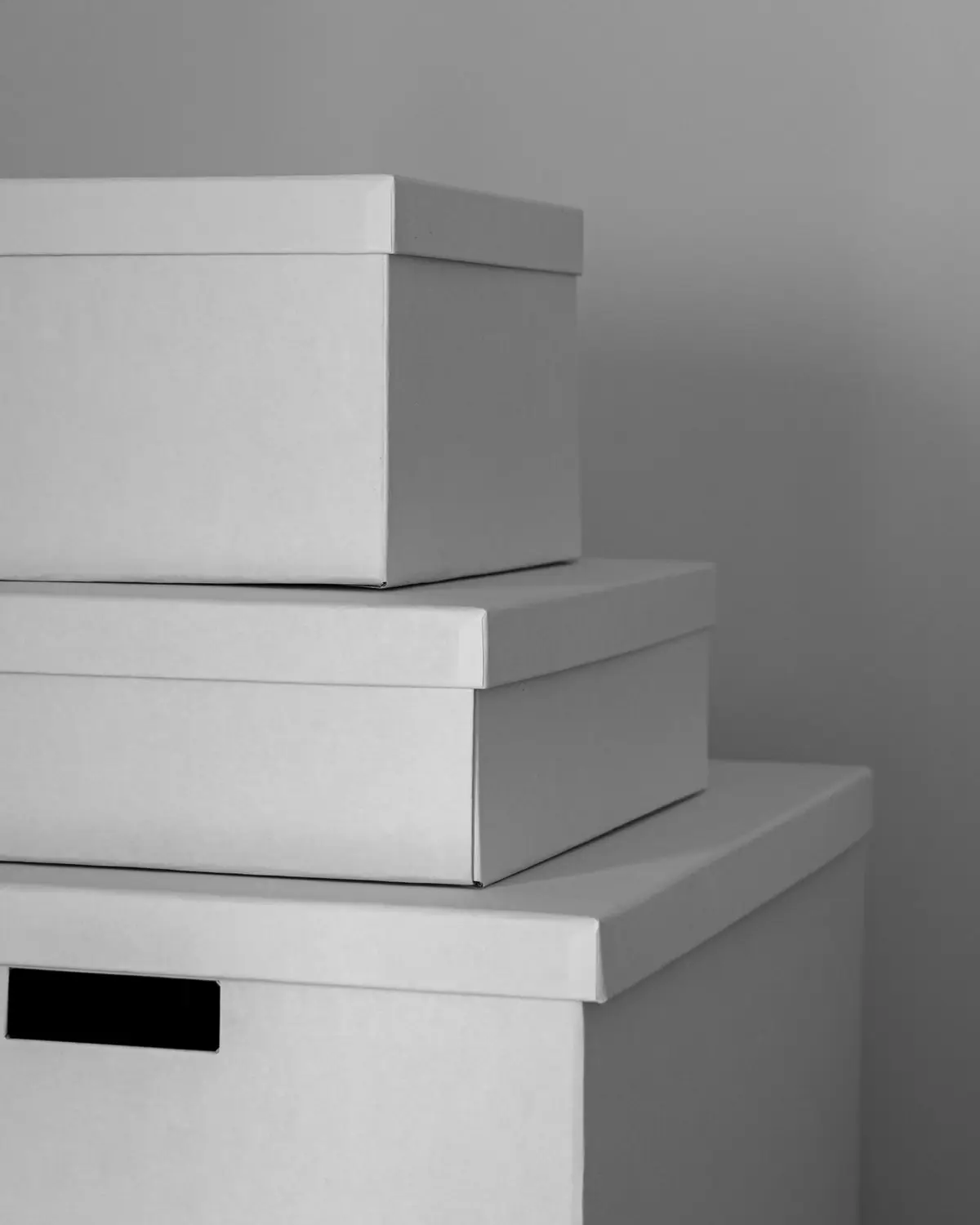 Three stacked white storage boxes