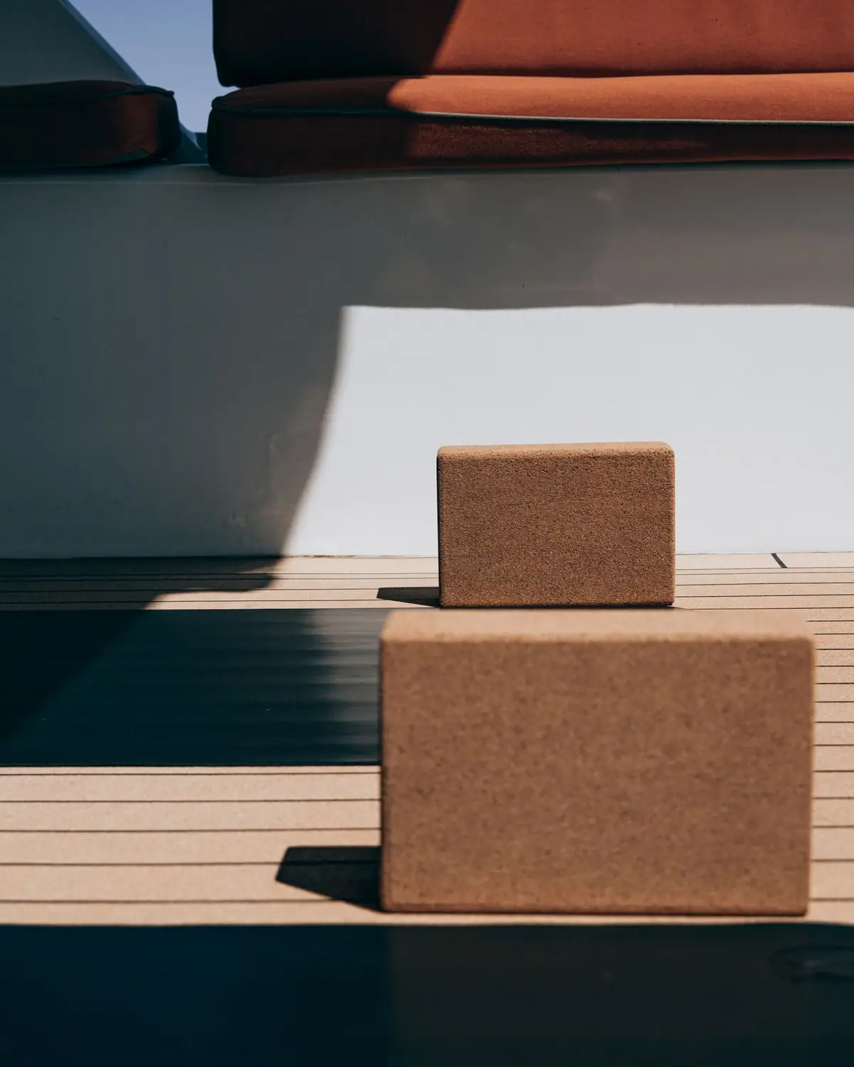 Yoga mats and cork blocks laid out on a wooden floor