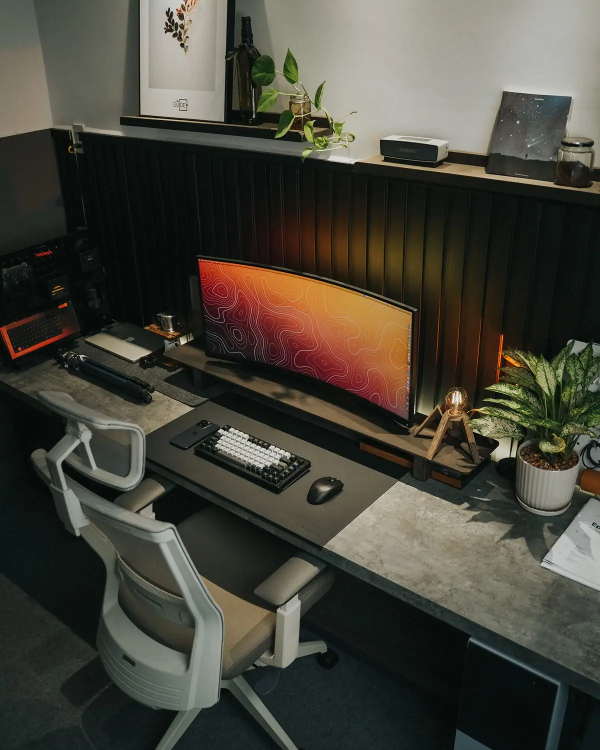 A modern office desk with a monitor and ergonomic chair