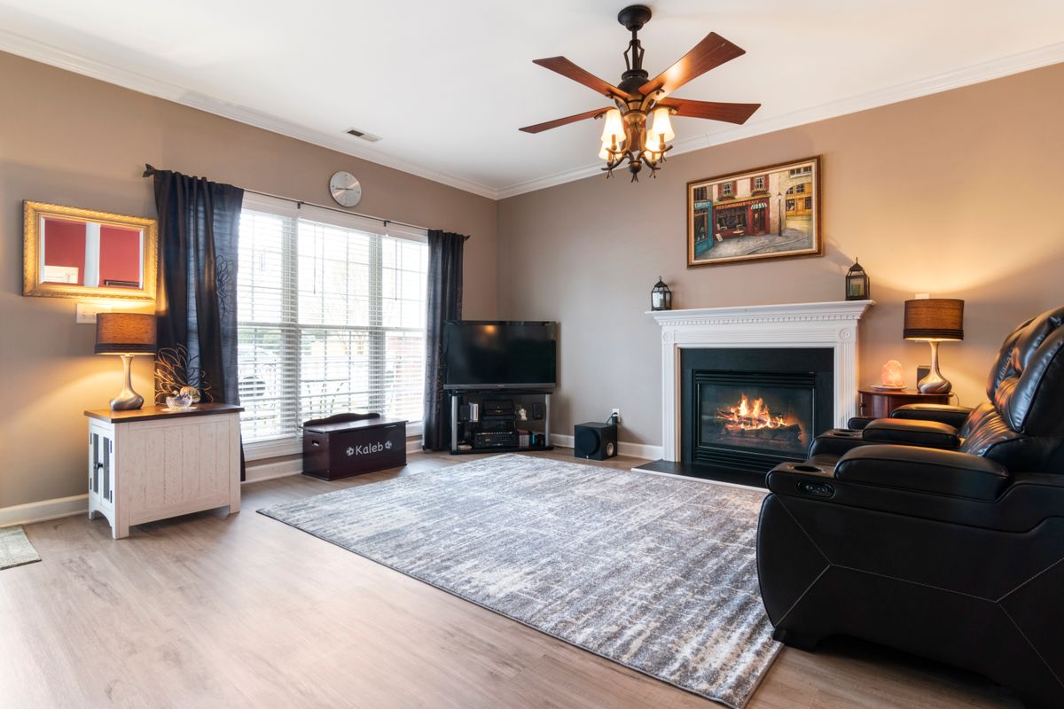 A white and gray area rug in a living room with a fireplace