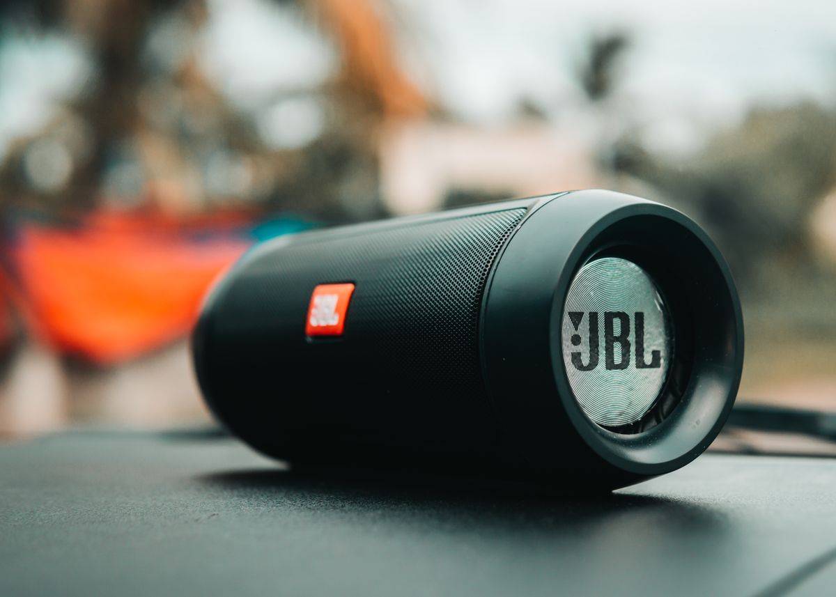 A black portable Bluetooth speaker on a surface