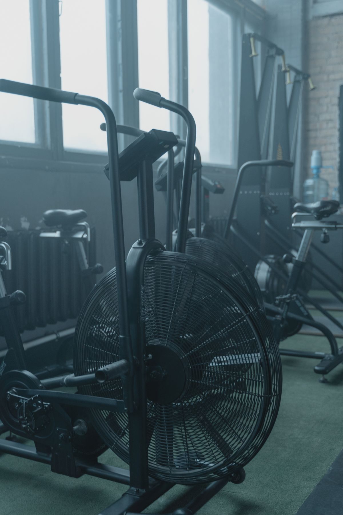A row of exercise bikes in a bright gym