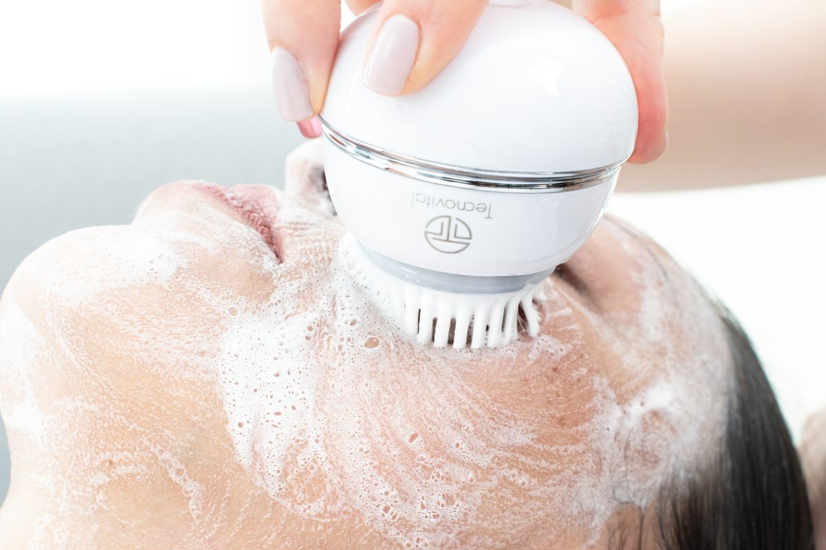 A facial cleansing brush being used with foam
