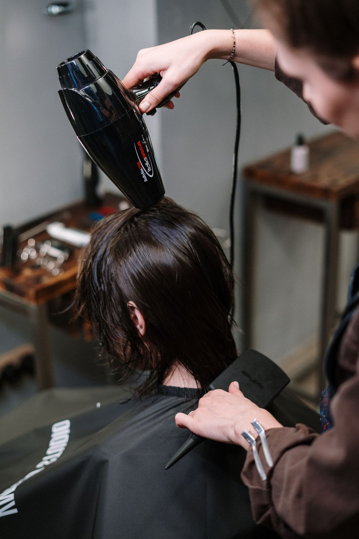 A stylist blow-drying a client's hair