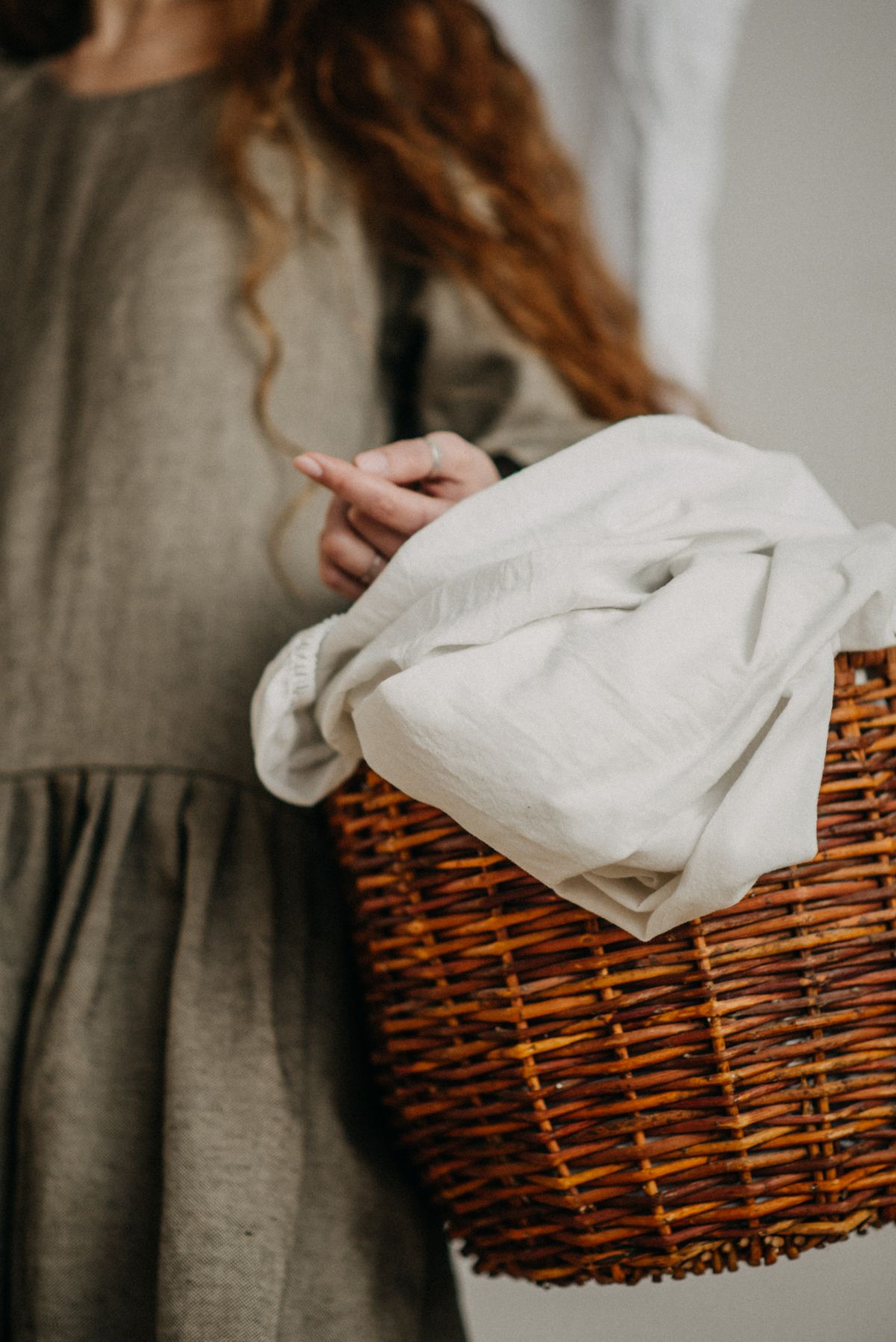 Folded linens in a woven laundry basket