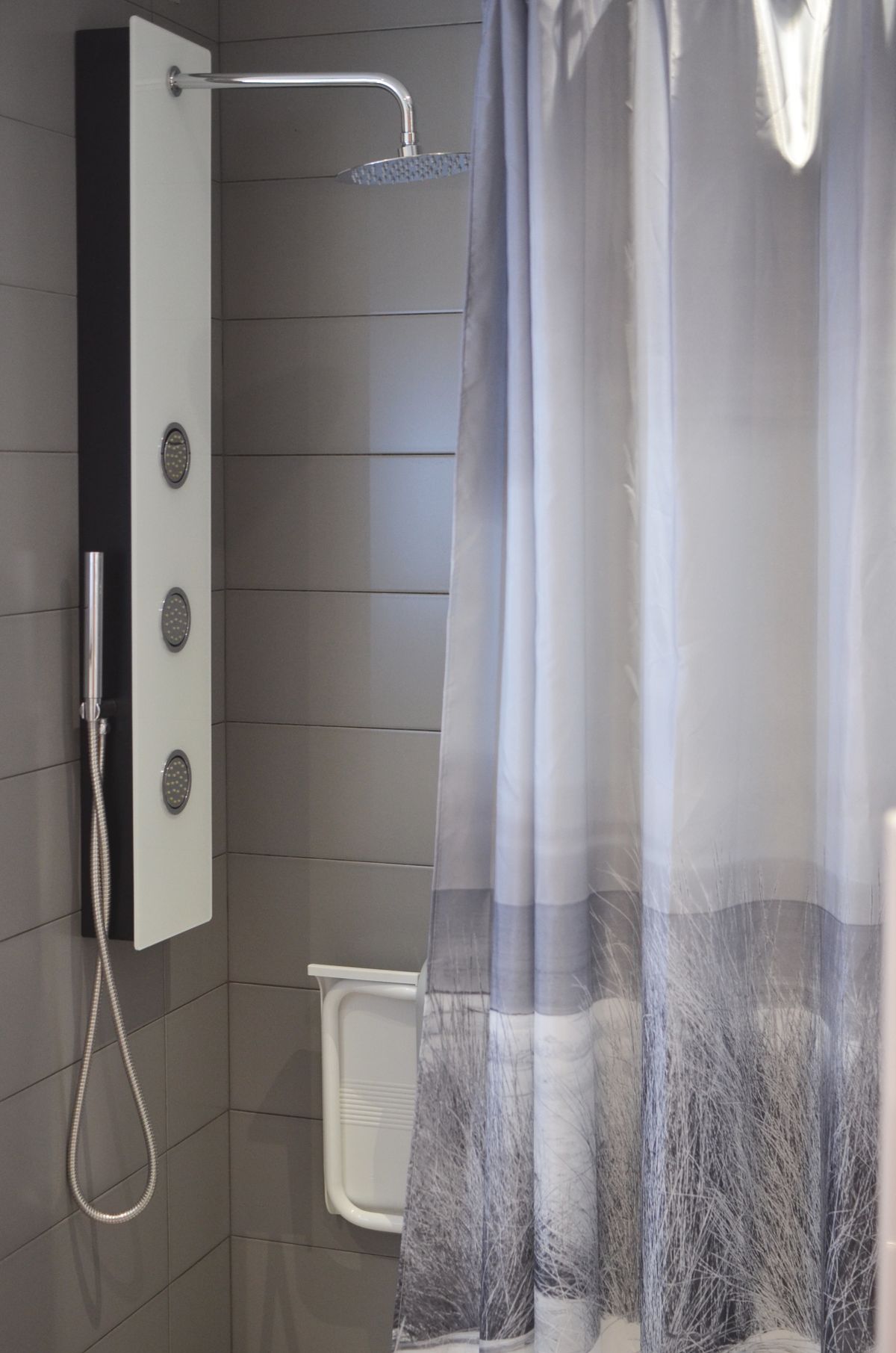 A modern bathroom with a shower cabin and curtain