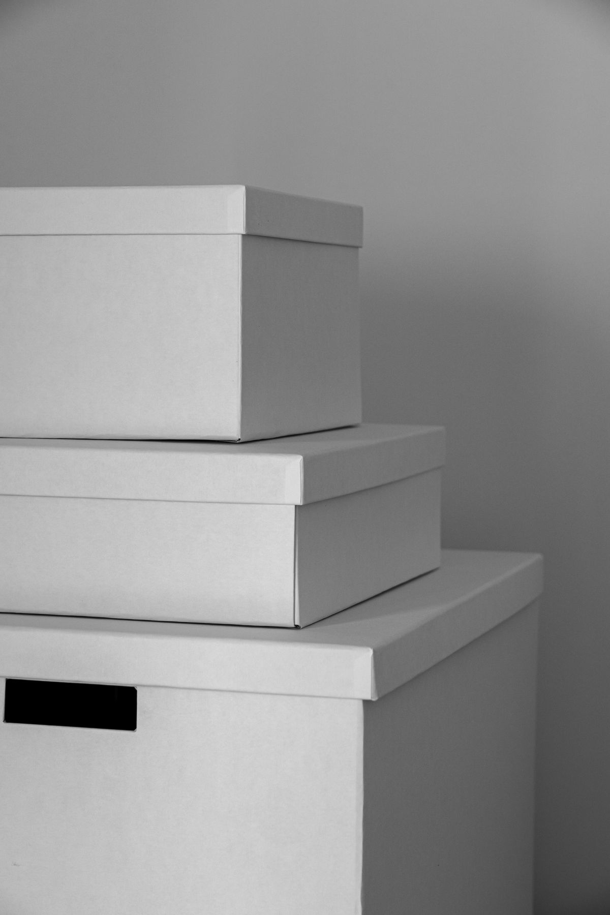 Three stacked white storage boxes