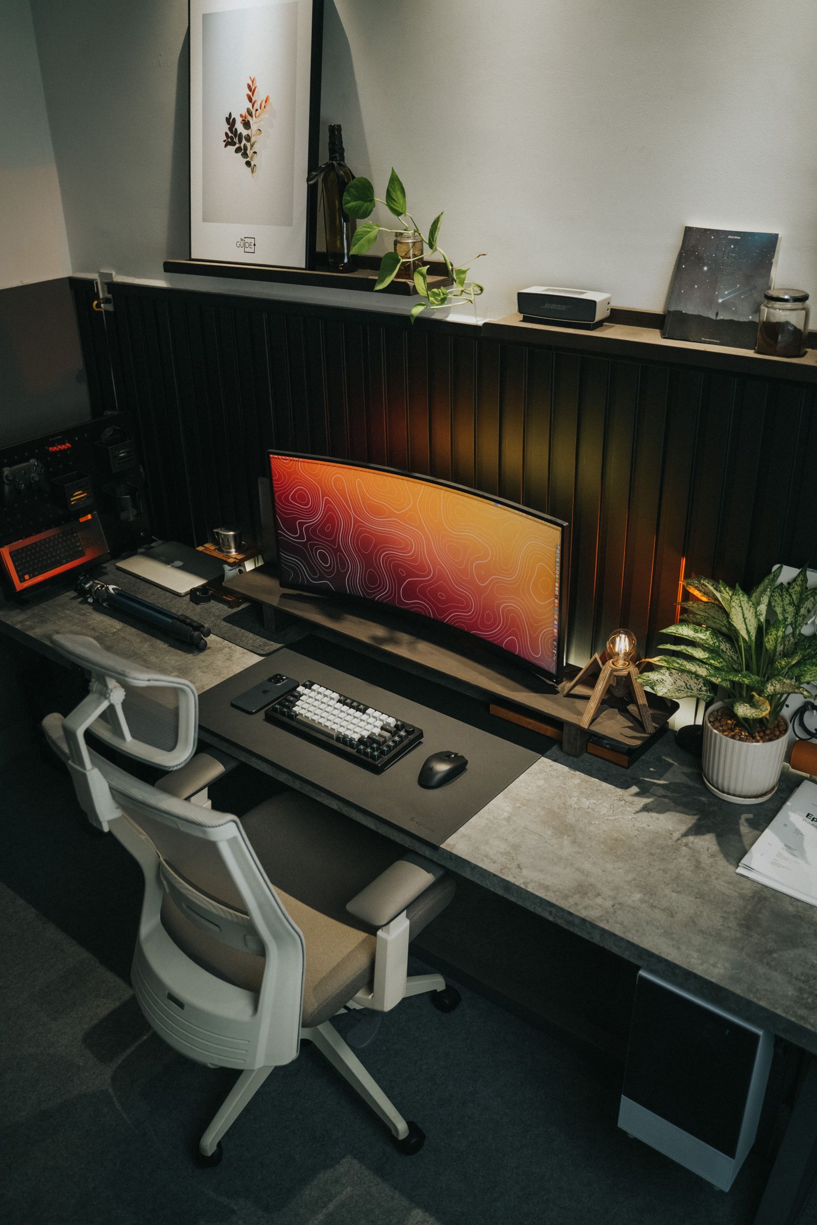 A modern office desk with a monitor and ergonomic chair